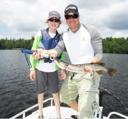 Fishing in the Adirondacks with a father and son catching a Northern Pike, 